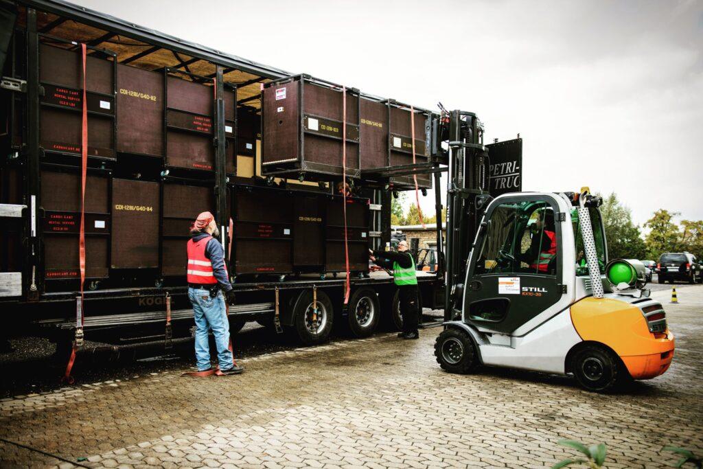 Cargo Carts beim effizienten Verladen mit Gabelstapler in einen Truck für platzsparende Veranstaltungslogistik ohne Leerraum.